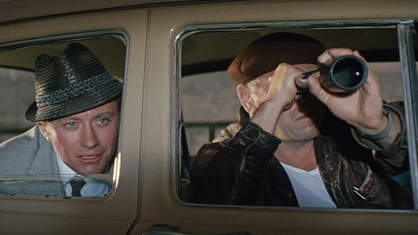 Какой фильм был показан на афише, когда Лёлик и Геша шпионили из машины?