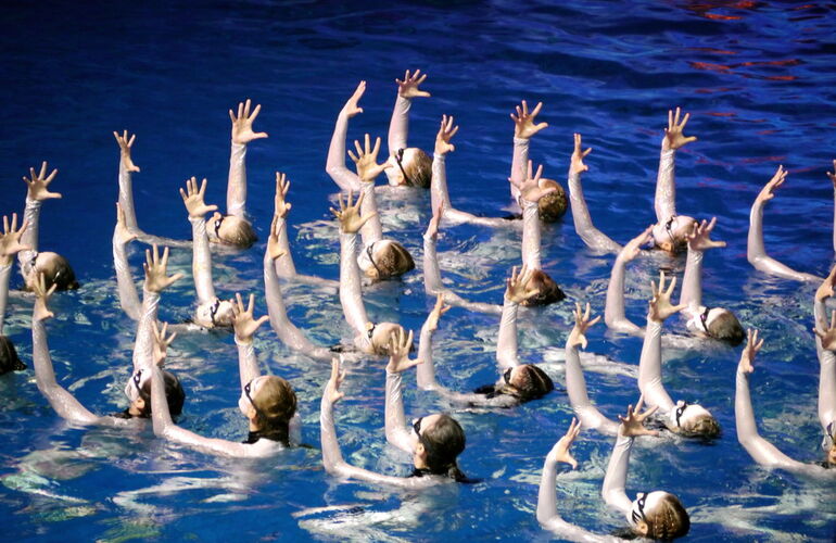 Какой олимпийский вид спорта шутя называют водным балетом и фигурным плаванием?